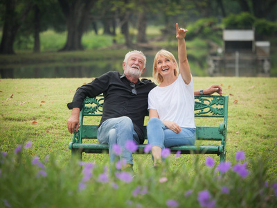两个快乐的老年人退休，男人和女人坐在公园里聊天