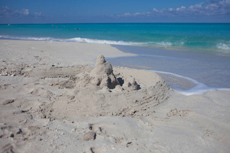 海滩上的沙堡。海浪附近易碎的沙房