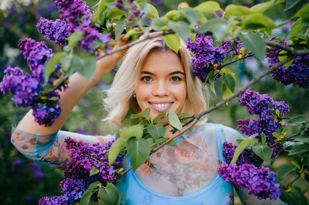 夏日盛开的紫薇花园中美丽温柔的女人的肖像。