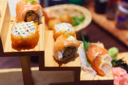 日本鲜鱼美食菜菜单三文鱼寿司和生鱼片品种装饰在木制台阶上的传统日本餐厅。 丰富鱼类营养和美味膳食概念的健康食品