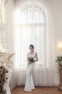 新娘的肖像在大窗户附近完全生长。 新娘带着一束白色郁金香