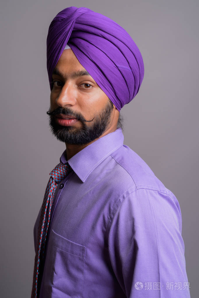 年轻英俊的印度锡克教徒商人戴头巾反对 gr