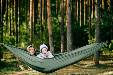 父亲和小女儿一起在森林的吊床上休息