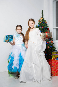 在画室的圣诞树旁摆着节日礼服的姐妹们