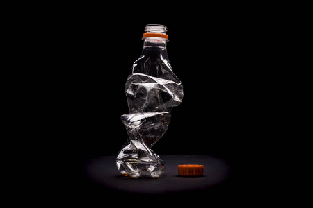 黑色细菌地上的塑料瓶。 击败塑料污染概念。