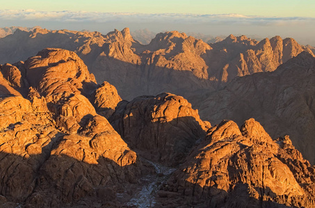 风景如画的日出在西奈山霍雷卜加巴尔穆萨摩西山。 埃及的西奈半岛。 背景中的浓雾。 朝圣地和著名的旅游目的地。