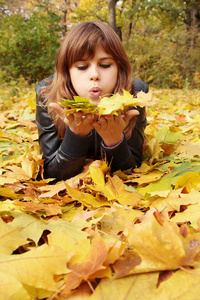 躺在秋叶上的一个女孩的肖像