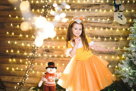 可爱的白种人小女孩穿着橙色衣服狐狸服装