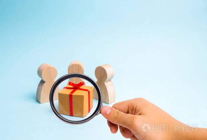 放大镜正在看聚集在礼物周围的人并准备打开它家庭假日圣诞节和新年