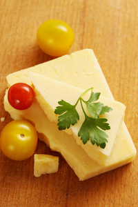 一块奶酪和小西红柿放在木板上