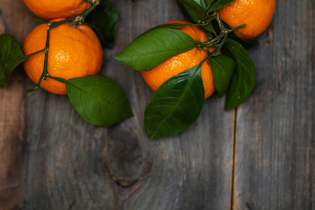 松树板上有叶子的橘子
