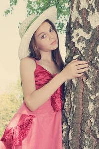 戴着帽子的梦幻女孩站在桦树附近