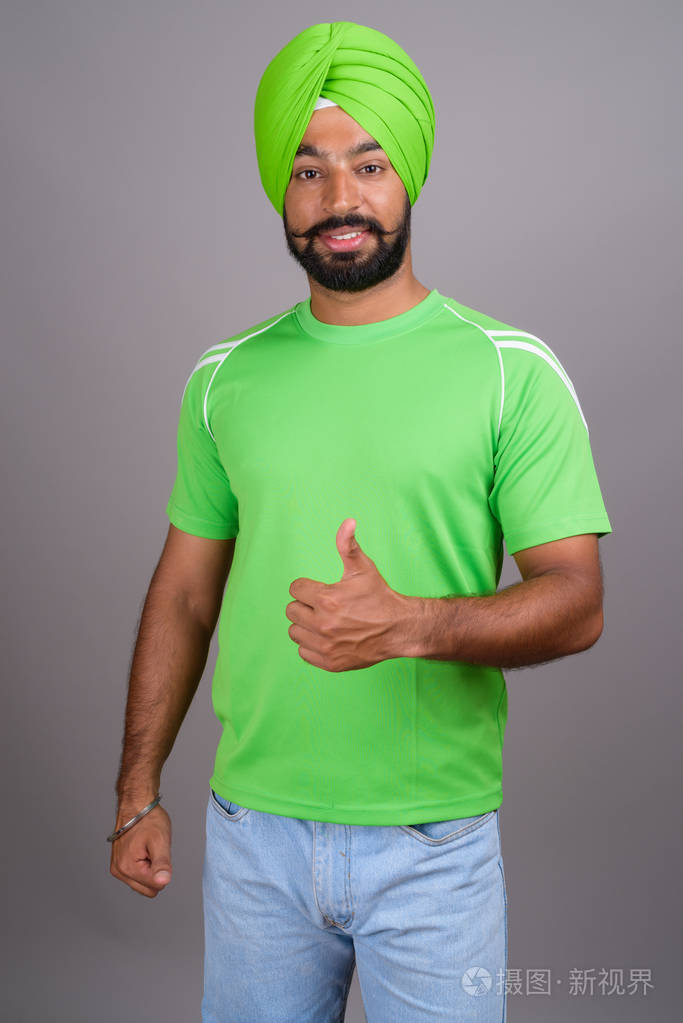 年轻英俊的印度锡克人,穿着头巾和绿色衬衫