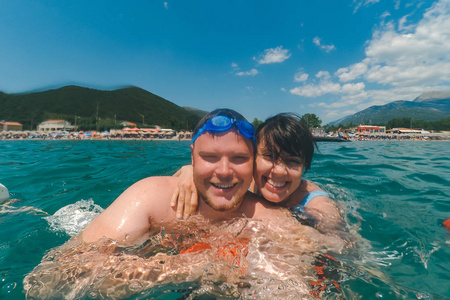 游泳动作情侣在夏季海洋游泳时,在动作相机上自拍. 模糊图像照片