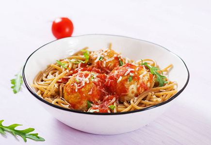 意大利意面部分，意大利面条，肉丸和帕尔马干酪，碗中，淡红色木背景