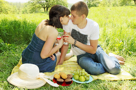 一对年轻夫妇在野餐时喝酒