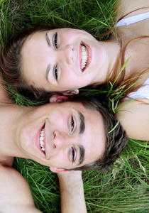年轻夫妇躺在草地上，俯视