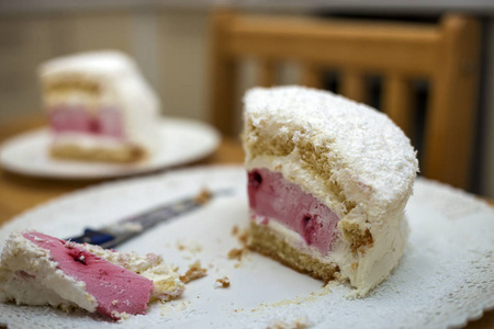 白色盘子，新鲜美味可口的自制水果饼干，白色和粉红色奶油蛋糕在厨房的桌子上，光线模糊的复制空间背景。 烘焙和健康食品制作理念。