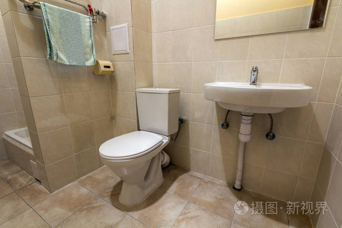 内部简单宽敞的空浴室设备,水槽,厕所和淋浴舱,复制空间背景的浅米色