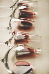 红酒在不同的玻璃杯上灰色混凝土背景选择性聚焦。 波约尔新酒吧酿酒厂葡萄酒脱胶概念