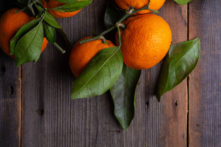 松树板上有叶子的橘子