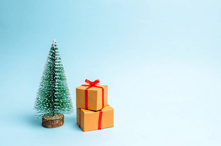 圣诞树和蓝色背景上的礼物。 极简主义。 家庭假日圣诞节和新年。 出售礼物。 卖出去。 生日惊喜。 圣诞晚会