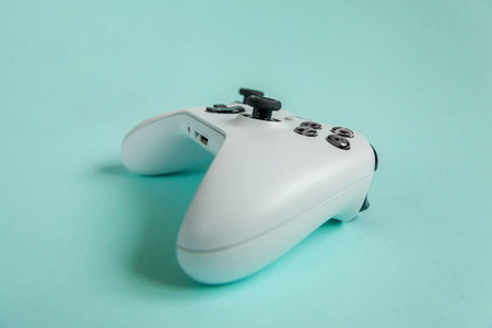 白色操纵杆Gamepad游戏控制台在蓝色色彩鲜艳的现代时尚别针背景。 电脑游戏竞争视频游戏控制对抗的概念。 网络符号