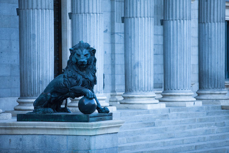 马德里西班牙美丽的历史建筑在市中心。 狮子在柱廊背景上的雕塑