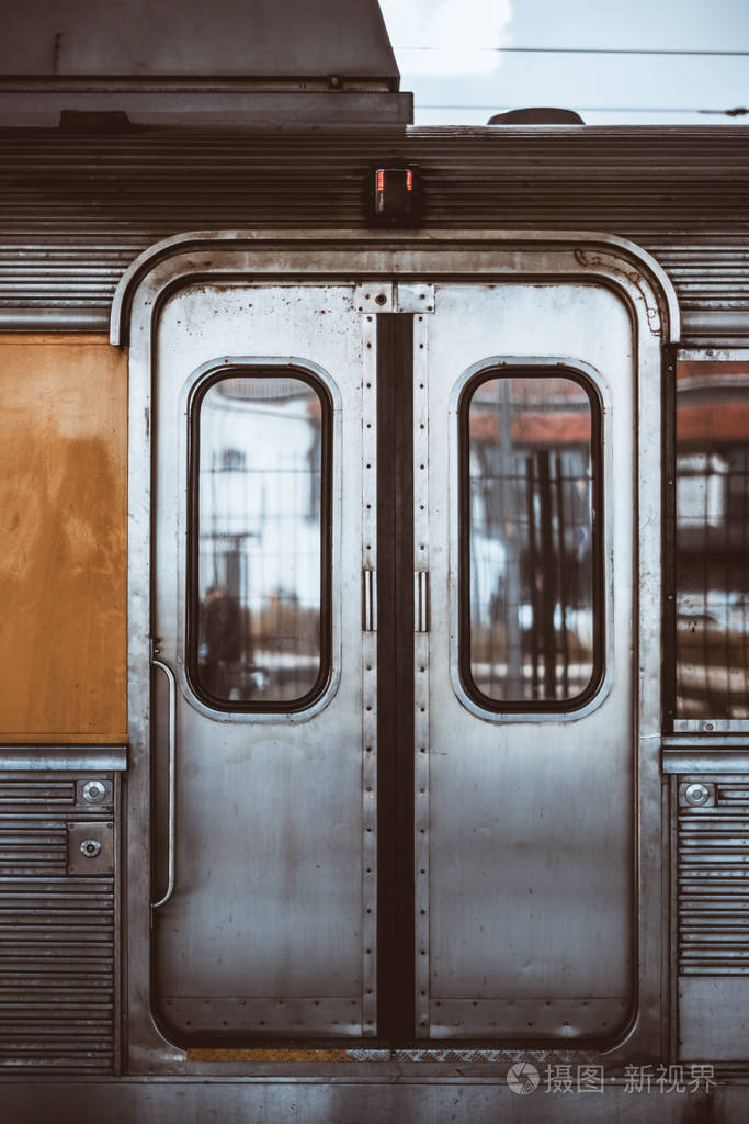 一辆欧洲郊区列车的镀铬车厢装饰的金属玻璃封闭自动门的垂直射击