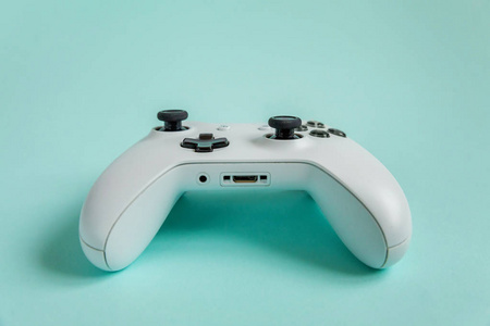 白色操纵杆游戏垫，游戏控制台上蓝色色彩鲜艳的现代时尚别针背景。电脑游戏竞赛视频游戏控制对抗概念。网络空间符号