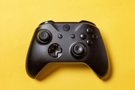 黑色操纵杆Gamepad游戏控制台黄色色彩鲜艳的现代时尚别针背景。 电脑游戏竞争视频游戏控制对抗的概念。 网络符号