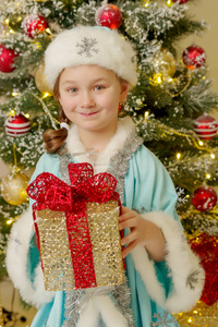 带着礼物在圣诞树附近的小女孩