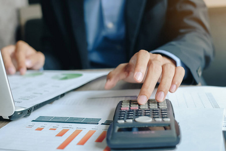 商人使用计算器进行分析，制定计划经理计算财务报告和图表。 商业财务和会计概念