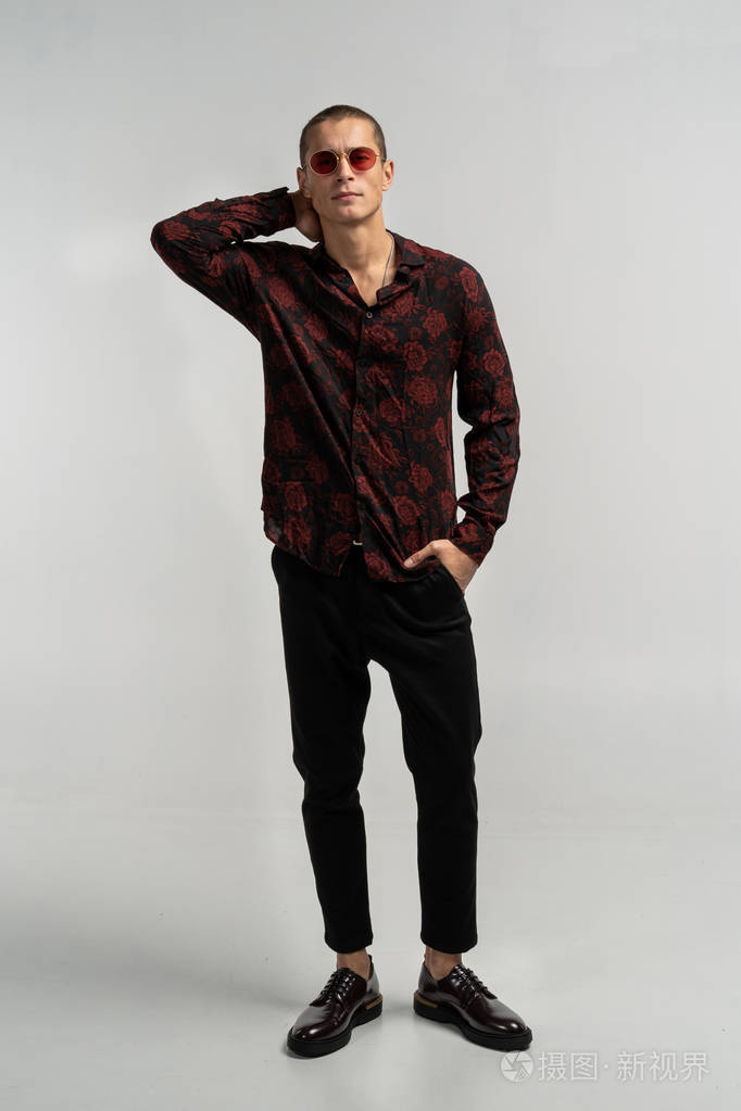 戴着太阳镜的年轻帅哥在演播室摆姿势