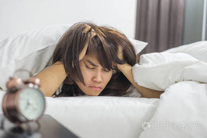 亚洲女人深夜躺在床上,年轻的女性睡在家里的卧室里.