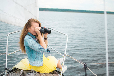 白种人女人在帆船上看双眼,游艇,多云的天空,放松照片