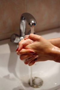 女人用肥皂和自来水洗手