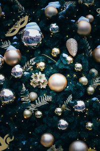 毛茸茸的冷杉装饰在剧院主题与黄金鲍布面具和树叶关闭。 圣诞节和新年背景