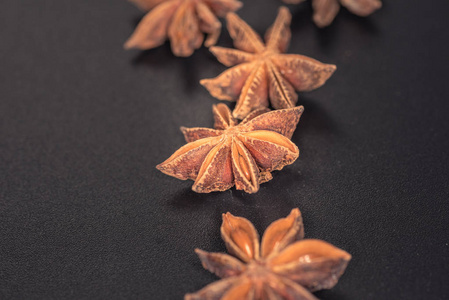 亚洲香料明星八角香料水果和种子分离在黑色背景特写。