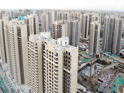 塔式起重机施工中大量建筑场地的鸟瞰图。 中国天津发展部分城市建设中的积木公寓。 房地产建筑工地。