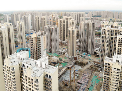 塔式起重机施工中大量建筑场地的鸟瞰图。 中国天津发展部分城市建设中的积木公寓。 房地产建筑工地。