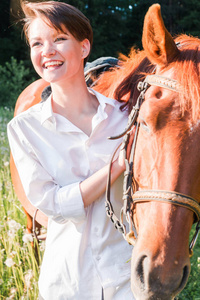 快乐的女孩旁边的马。水平照片