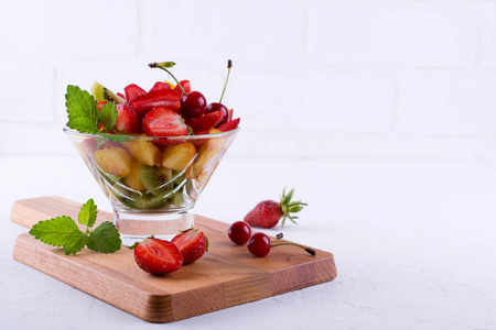 玻璃碗里有五颜六色的水果沙拉。 草莓猕猴桃和杏