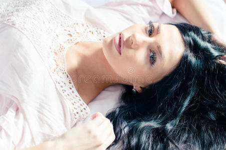 蓝眼睛穿着白衬衫的女人在床上放松