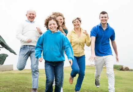 微笑的一家人在草地上奔跑图片