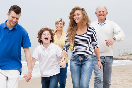 快乐的一家人在沙滩上散步图片