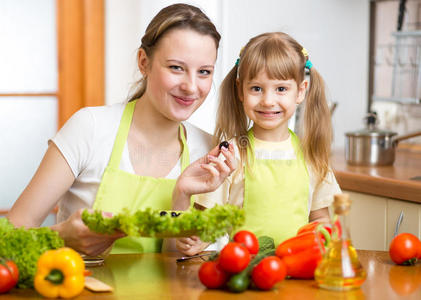 年轻的母亲和孩子做蔬菜沙拉