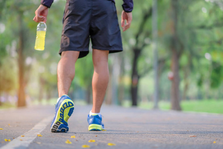 男性跑步者在外面的路上跑步,亚洲运动员在阳光明媚的早晨慢跑和在
