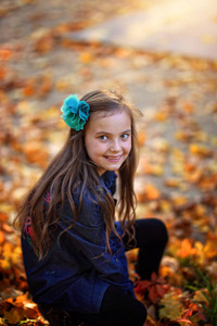 一个在秋天公园微笑的年轻女孩
