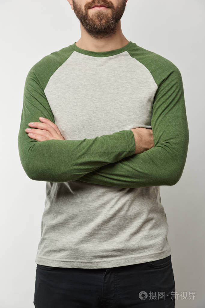 部分视角的人与手臂交叉在拉格兰袖子棒球衫与复制空间隔离在灰色